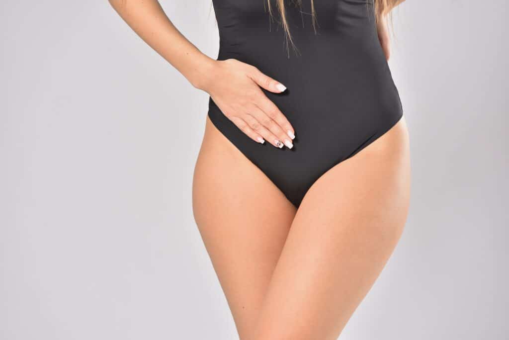 Woman holding her lower abdomen in pain, concept of female healt